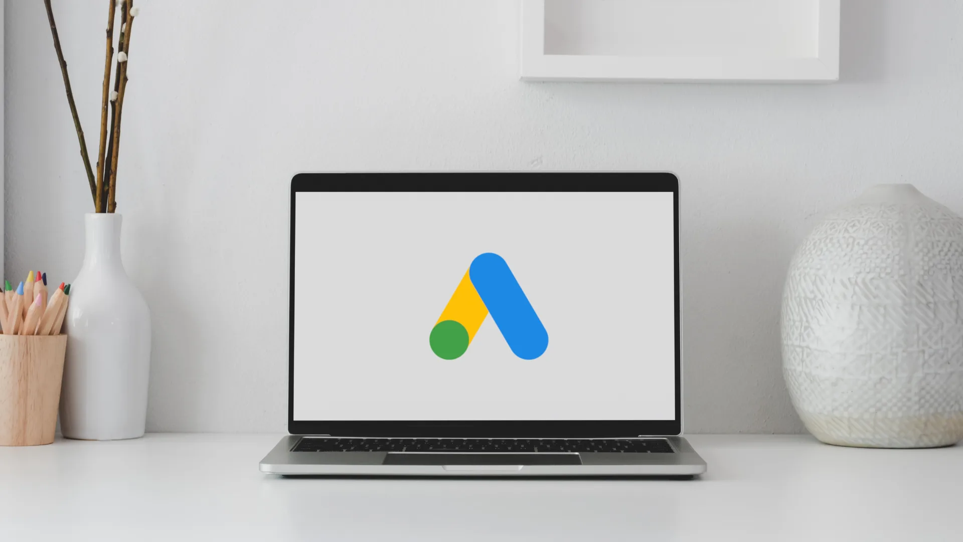 Aufgeklappter Laptop steht auf einem modern dekorierten Tisch. Das Display des Laptops zeigt ein Google Logo.